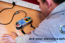 Image of electrician using electrical testing equipment on a plug socket